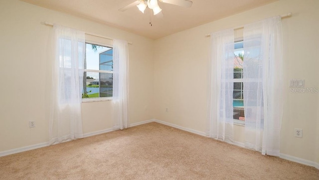 unfurnished room with ceiling fan and light carpet