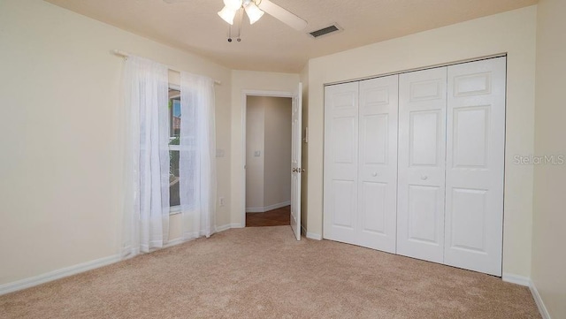 unfurnished bedroom featuring a closet, ceiling fan, and light colored carpet