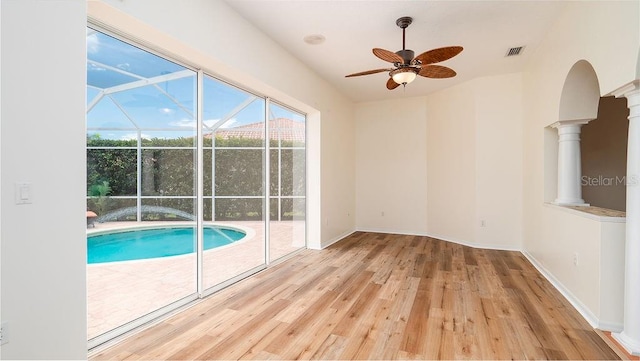 view of swimming pool with decorative columns and ceiling fan