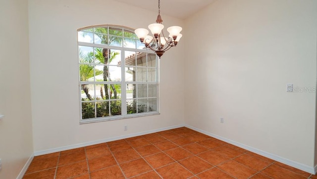 tiled empty room featuring a chandelier