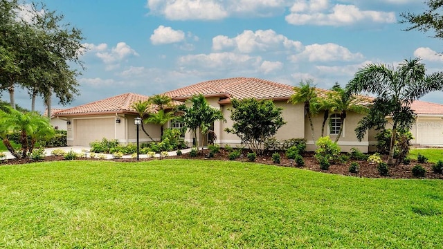 mediterranean / spanish house featuring a garage and a front lawn