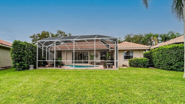 rear view of house with a lanai, a patio, and a yard