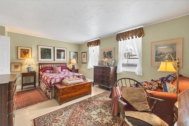 bedroom with light tile patterned floors, a textured ceiling, and baseboards