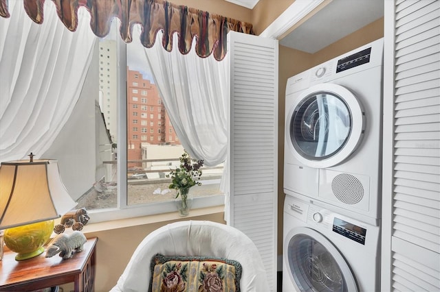 clothes washing area with stacked washer / drying machine and laundry area