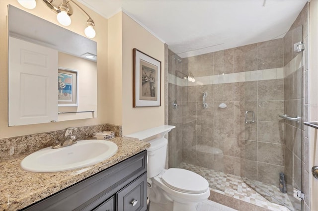 bathroom with ornamental molding, vanity, toilet, and a shower stall