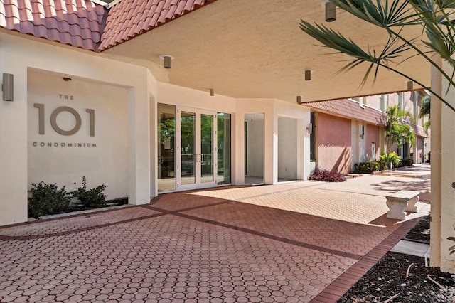 exterior space featuring a tiled roof and stucco siding