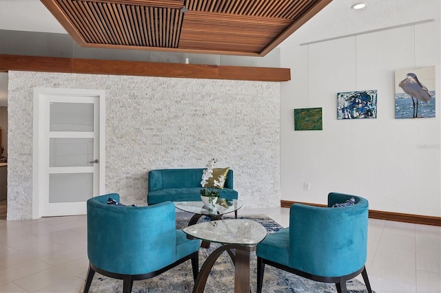 sitting room featuring built in shelves, wooden ceiling, and light tile patterned floors