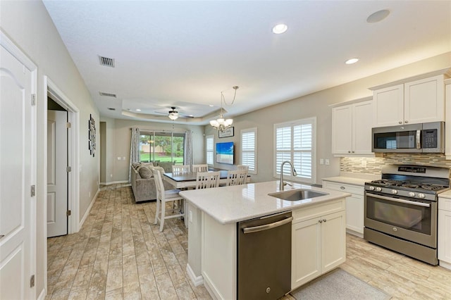 kitchen with appliances with stainless steel finishes, a wealth of natural light, pendant lighting, and sink