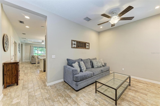 living room with ceiling fan and light hardwood / wood-style flooring