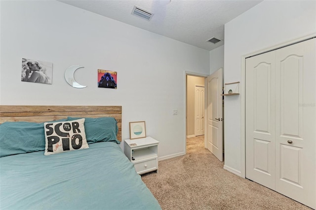 carpeted bedroom featuring a textured ceiling and a closet