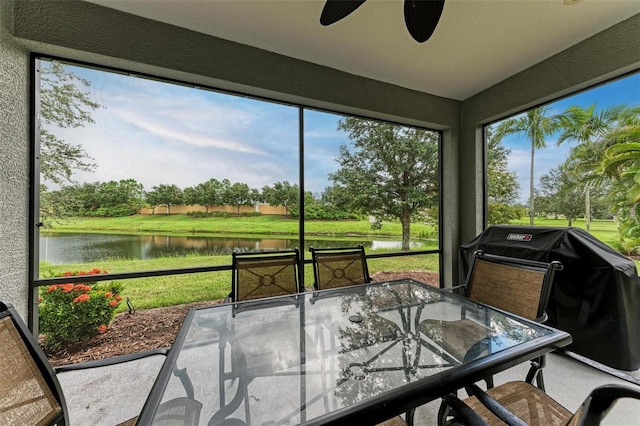 sunroom / solarium with a water view, ceiling fan, and a healthy amount of sunlight