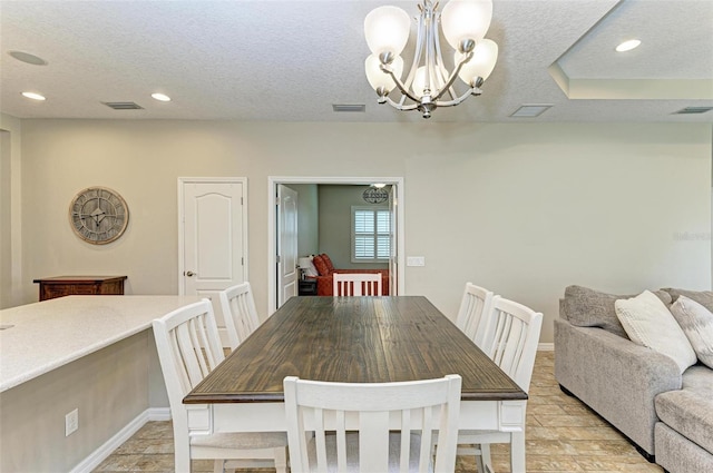 dining area featuring a chandelier and a textured ceiling