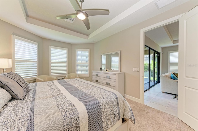 bedroom with a raised ceiling, light carpet, and ceiling fan