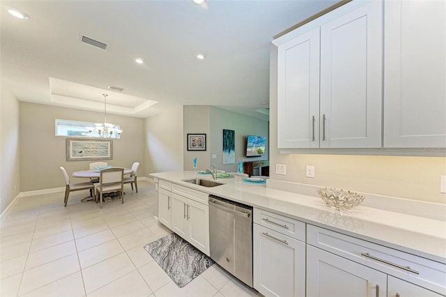 kitchen featuring pendant lighting, sink, white cabinets, stainless steel dishwasher, and a raised ceiling