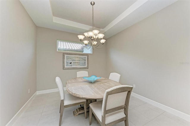 dining area featuring a tray ceiling, a chandelier, and light tile patterned floors