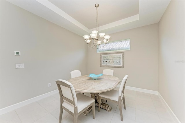 dining room featuring light tile patterned flooring, a chandelier, and a tray ceiling