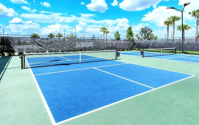 view of tennis court featuring basketball hoop