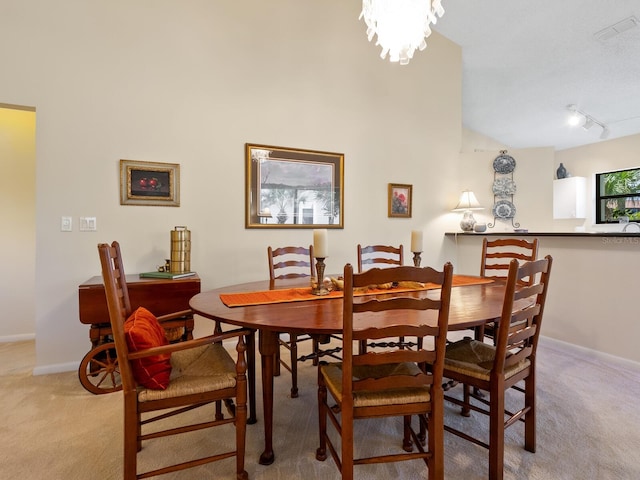 dining area featuring light colored carpet and rail lighting