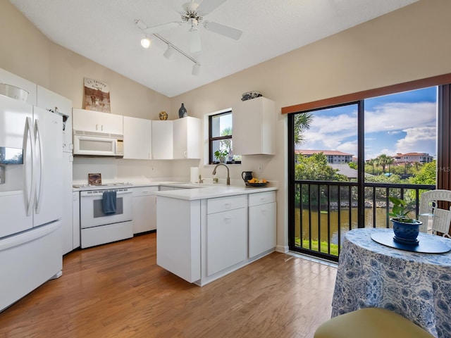 kitchen with light hardwood / wood-style floors, vaulted ceiling, white cabinets, white appliances, and ceiling fan