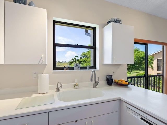 kitchen with white cabinetry, white dishwasher, and a textured ceiling