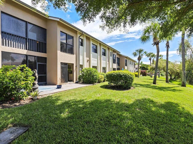 view of property's community with a yard and a patio area