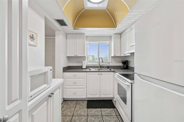 kitchen with white cabinetry, range, sink, and refrigerator