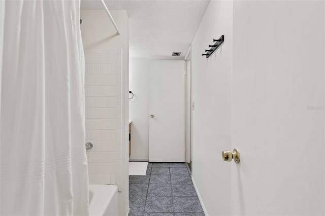 bathroom featuring tile patterned flooring, a textured ceiling, and shower / bathtub combination with curtain