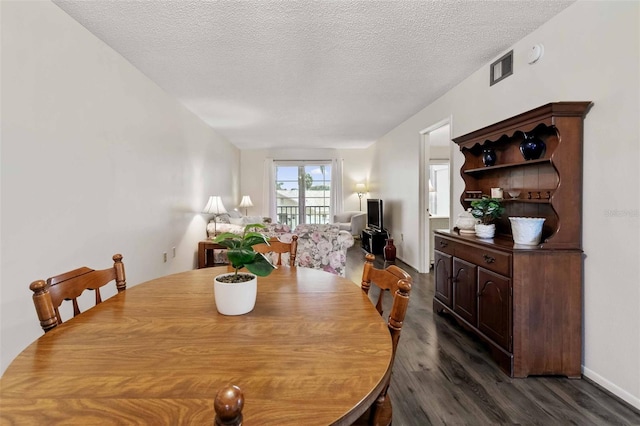 dining space featuring hardwood / wood-style flooring and a textured ceiling