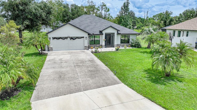 view of front of home with roof with shingles, stucco siding, a front yard, a garage, and driveway