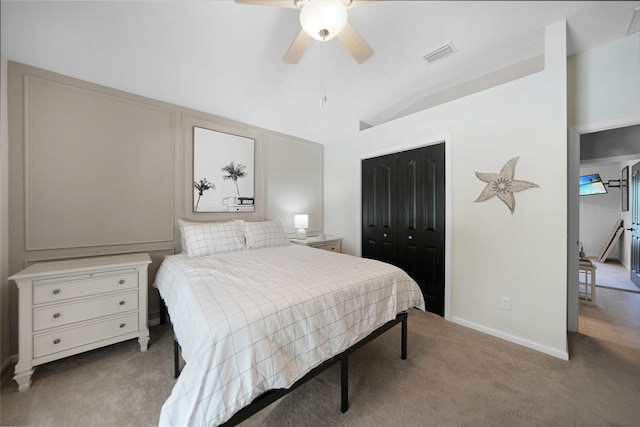 bedroom featuring light carpet, vaulted ceiling, a closet, and ceiling fan