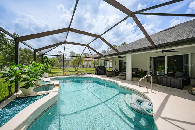 view of swimming pool with a patio area, ceiling fan, glass enclosure, and an outdoor hangout area