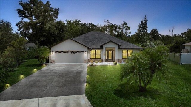 view of front of property featuring a lawn and a garage