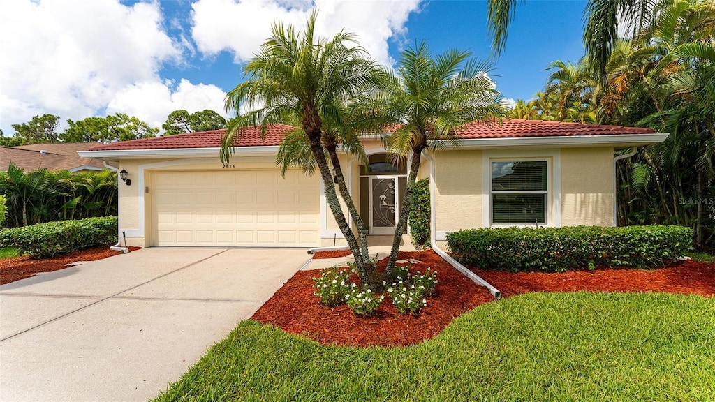 mediterranean / spanish-style home with a garage and a front yard