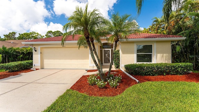 mediterranean / spanish-style home with a garage and a front yard