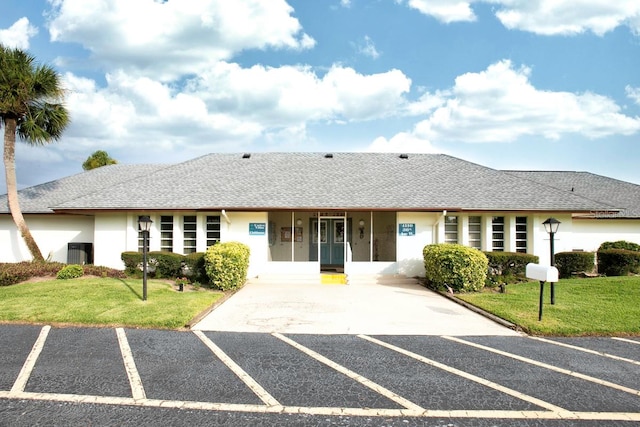 exterior space with central air condition unit and a front lawn