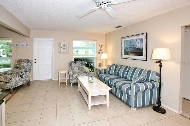 tiled living room featuring ceiling fan and a textured ceiling