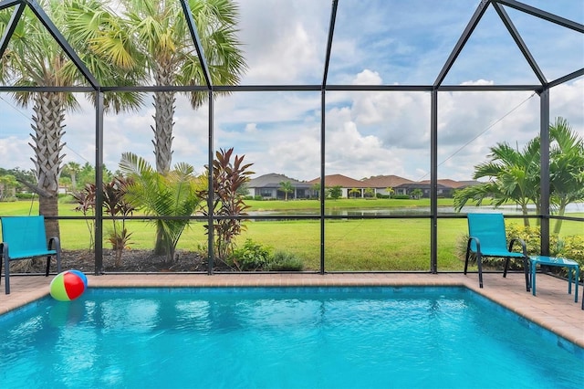 view of swimming pool with a yard and a lanai