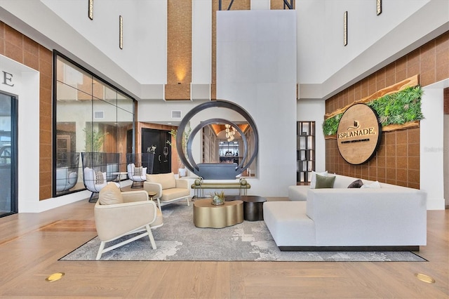 living room featuring a towering ceiling and light hardwood / wood-style flooring