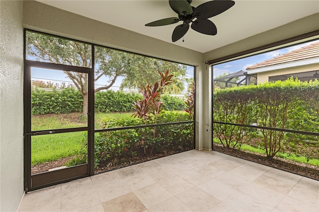 unfurnished sunroom featuring ceiling fan