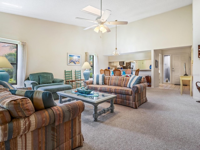 carpeted living room featuring a healthy amount of sunlight, ceiling fan, and high vaulted ceiling