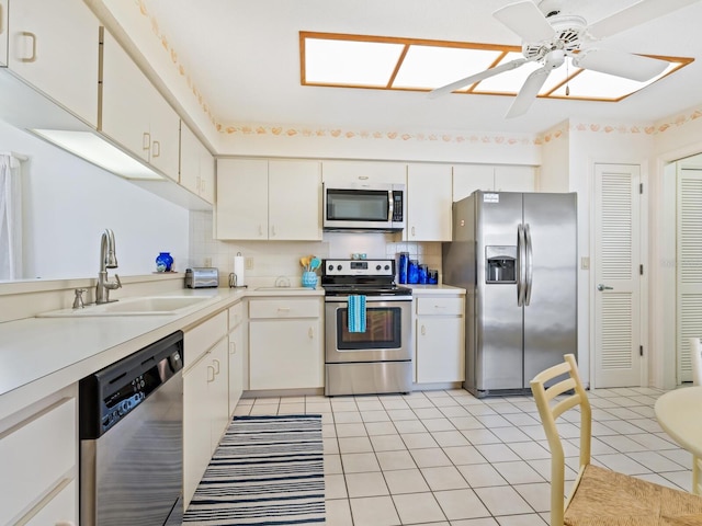 kitchen featuring sink, ceiling fan, decorative backsplash, appliances with stainless steel finishes, and white cabinets