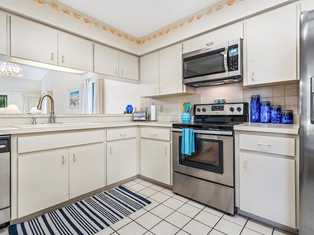 kitchen featuring light tile patterned flooring, backsplash, stainless steel appliances, and sink