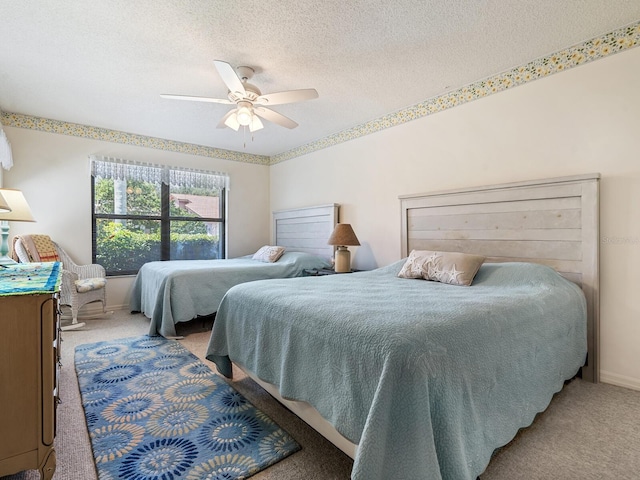 bedroom with ceiling fan, light carpet, and a textured ceiling