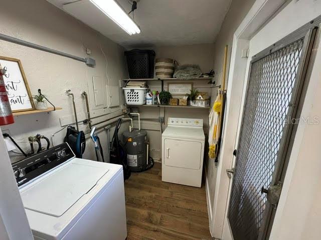 laundry area with laundry area, dark wood-type flooring, washer hookup, and electric water heater