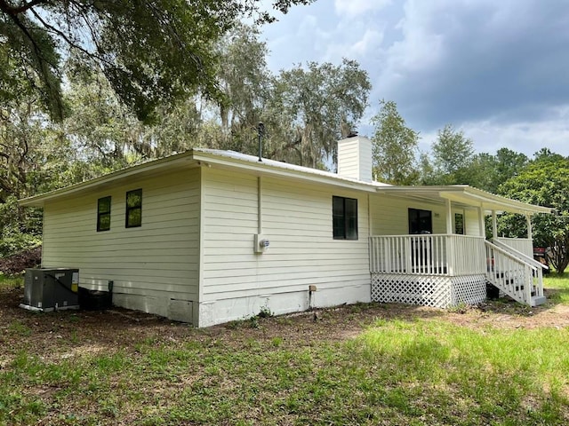 rear view of house featuring covered porch and cooling unit