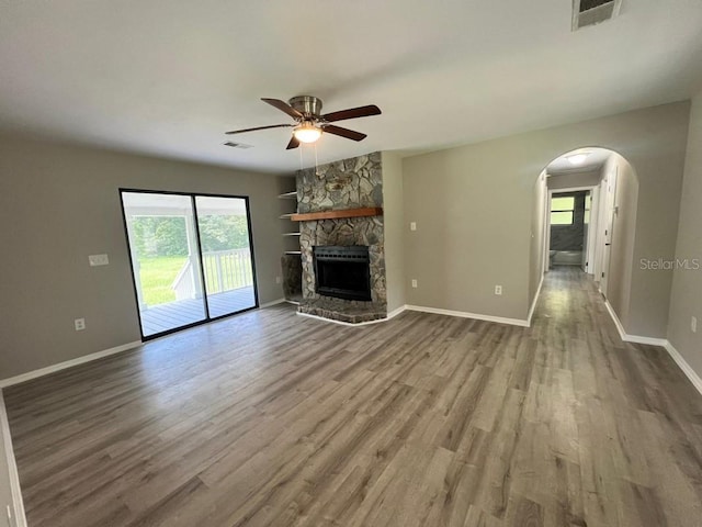 unfurnished living room with hardwood / wood-style flooring, a fireplace, and ceiling fan