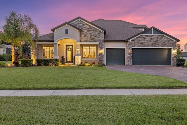 view of front of home with a yard and a garage