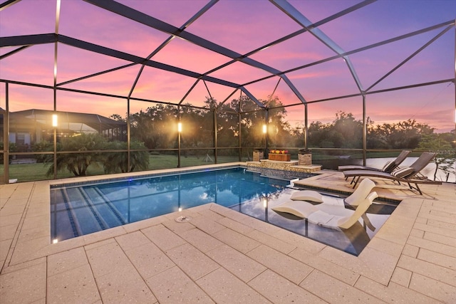 pool at dusk featuring a patio area and a lanai