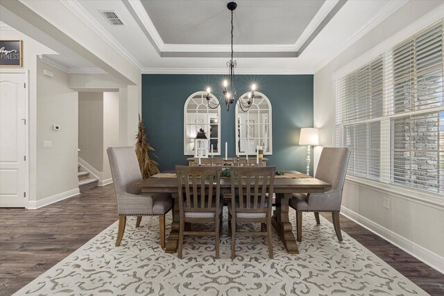 dining space with a raised ceiling, dark hardwood / wood-style floors, and ornamental molding