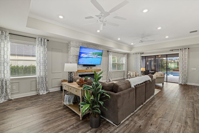 living room featuring dark hardwood / wood-style floors, ceiling fan, and ornamental molding